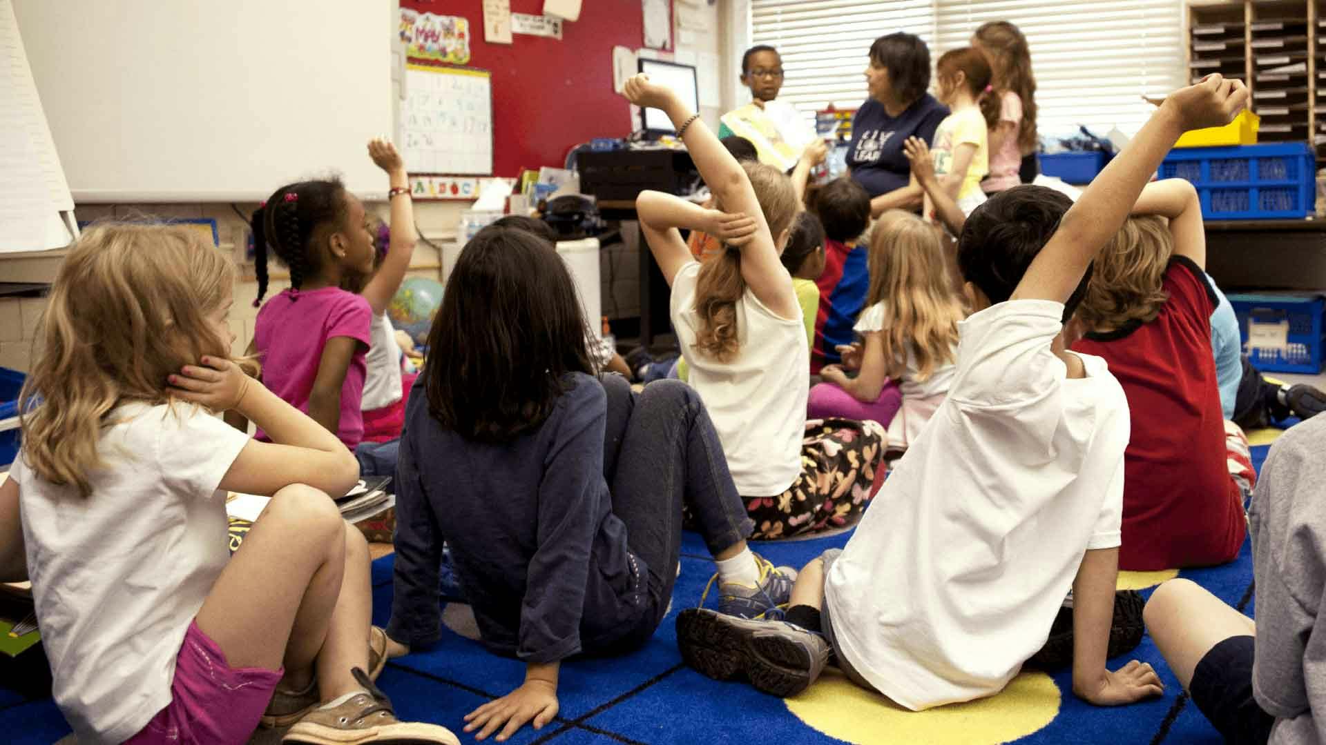 Children sat on the floor in a classroom learning number bonds in a maths lesson