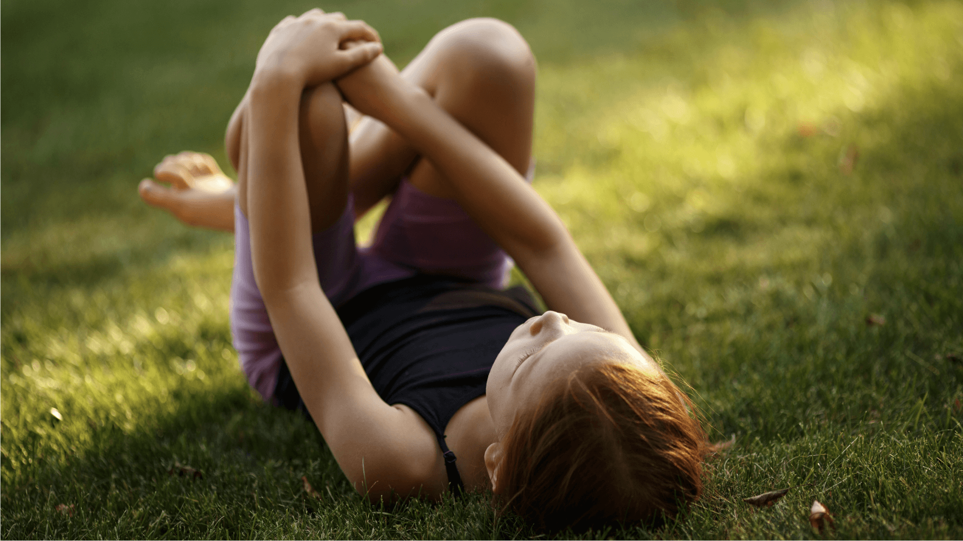 A child resting in the grass looking up at the sky
